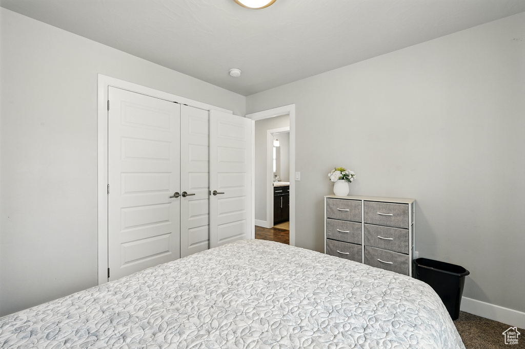 Bedroom featuring a closet, baseboards, and dark carpet