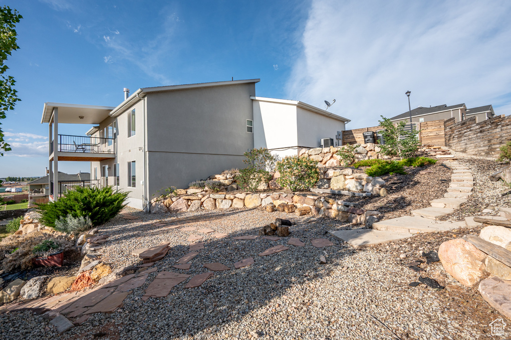 View of side of property featuring a balcony and stucco siding