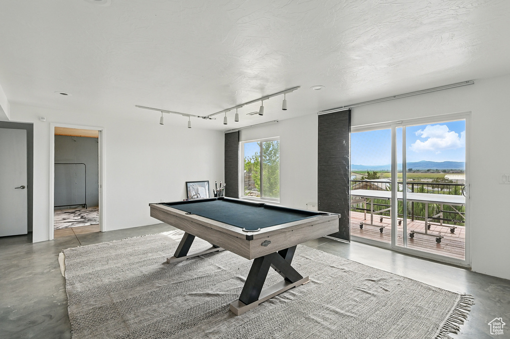 Recreation room with concrete floors, billiards, track lighting, and a mountain view