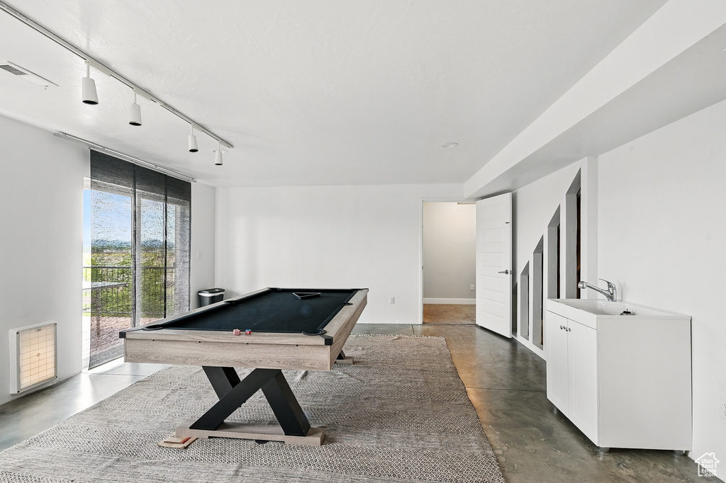 Recreation room featuring finished concrete floors, track lighting, billiards table, a sink, and baseboards