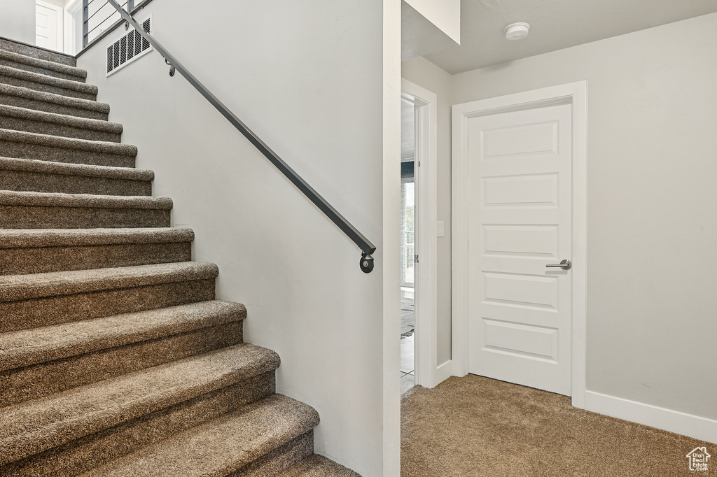 Staircase featuring carpet flooring and baseboards