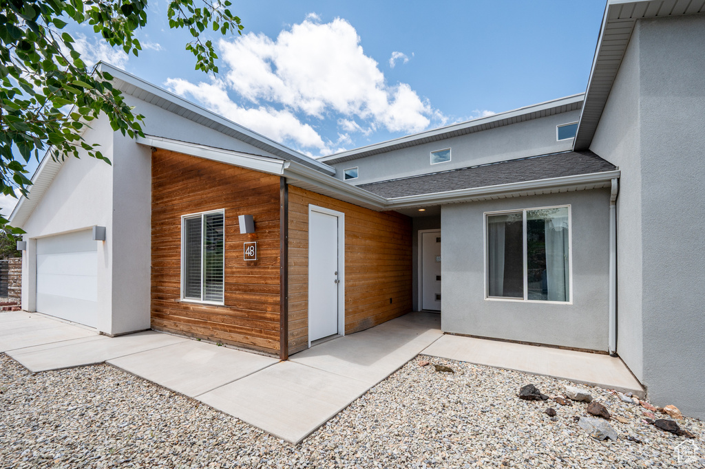 View of front facade with an attached garage and stucco siding