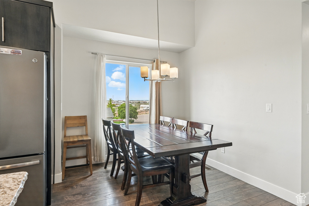 Dining space featuring a chandelier, hardwood / wood-style flooring, and baseboards