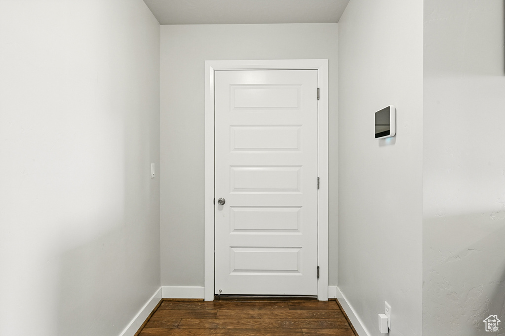 Hall featuring dark wood-type flooring and baseboards