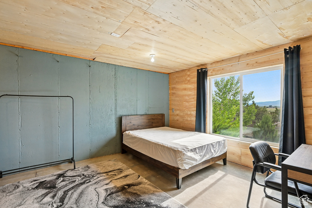 Bedroom featuring wooden ceiling and concrete floors