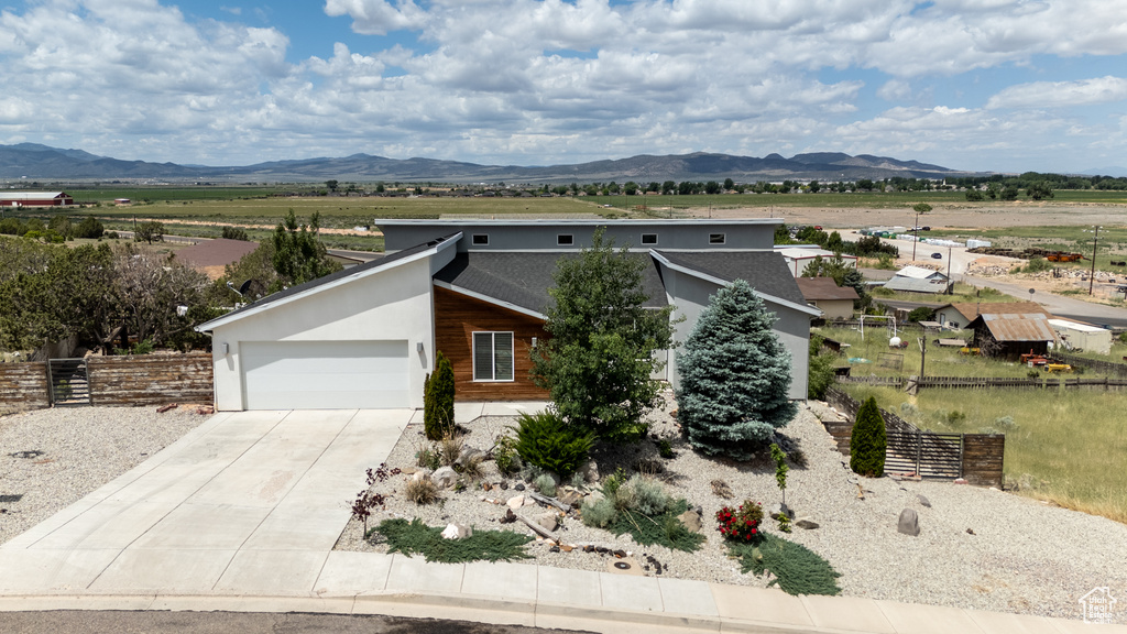 Contemporary house featuring an attached garage, concrete driveway, and a mountain view