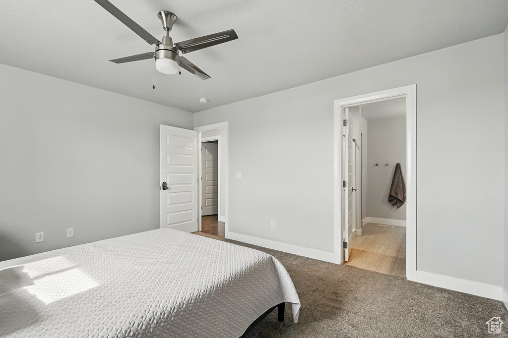 Bedroom with baseboards, carpet flooring, ceiling fan, and ensuite bathroom