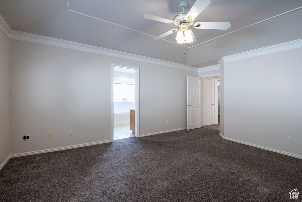 Spare room featuring carpet flooring, crown molding, ceiling fan, and baseboards