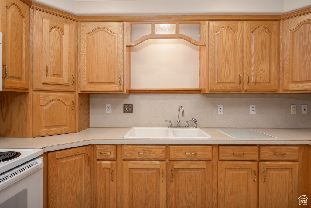 Kitchen with a sink, light countertops, and electric stove
