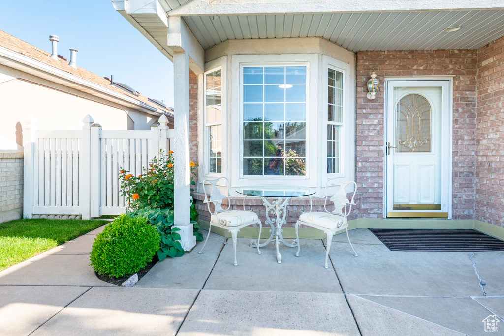 View of exterior entry with brick siding and a patio area
