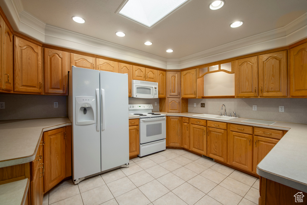 Kitchen with white appliances, a sink, crown molding, brown cabinetry, and light countertops