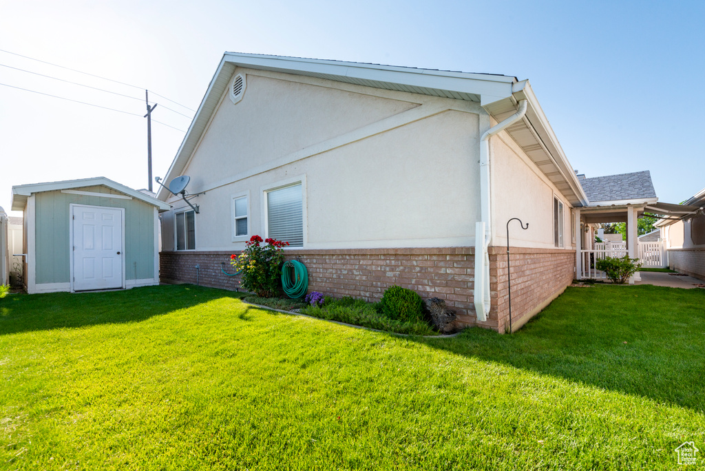 Back of property featuring brick siding, a lawn, and stucco siding