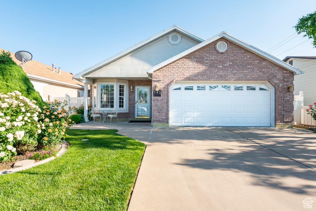 Ranch-style home with brick siding, driveway, and an attached garage