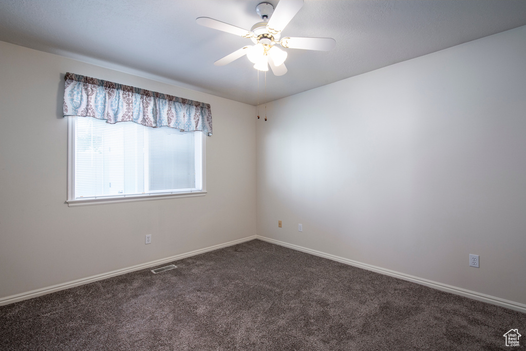 Unfurnished room with carpet, a ceiling fan, and baseboards