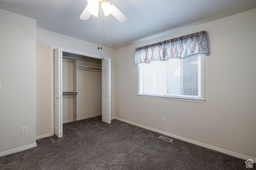 Unfurnished bedroom featuring carpet, a closet, baseboards, and ceiling fan
