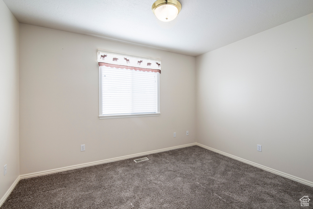 Carpeted empty room featuring baseboards