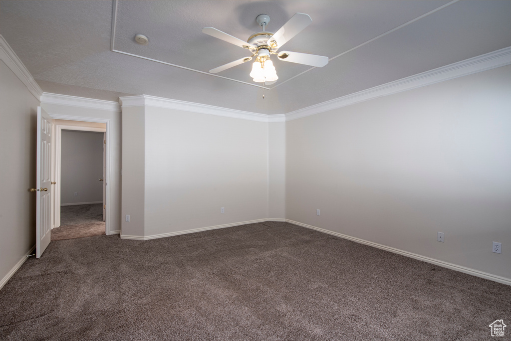 Carpeted spare room with a ceiling fan, ornamental molding, a smoke detector, and baseboards