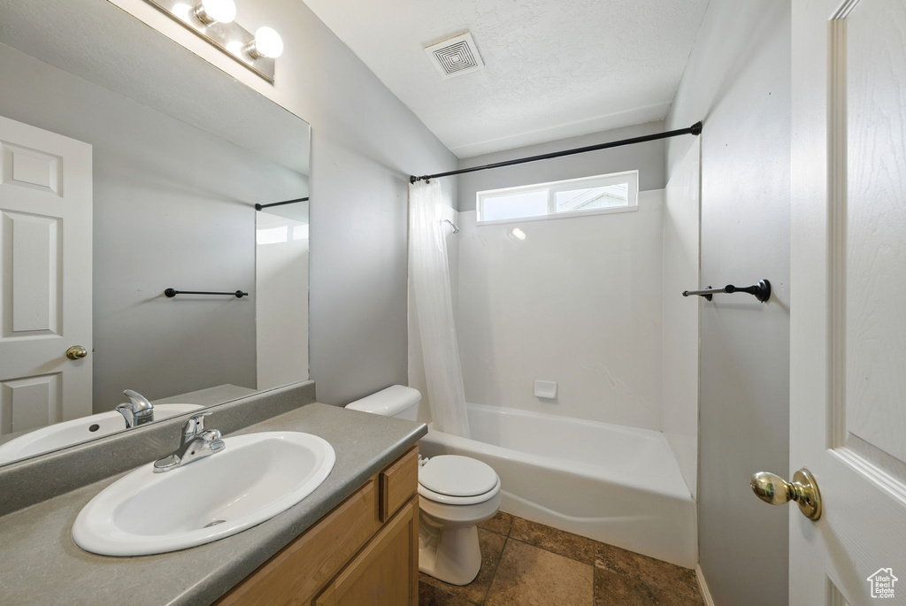 Bathroom featuring toilet, vanity, and shower / tub combo