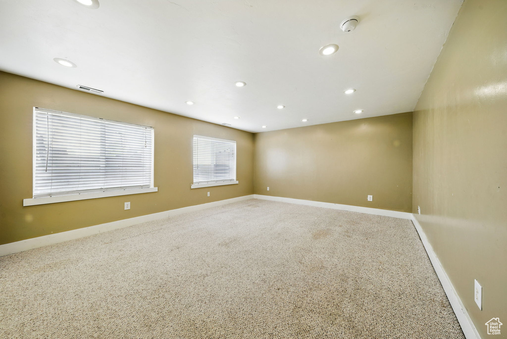 Spare room with carpet floors, baseboards, recessed lighting, and a smoke detector
