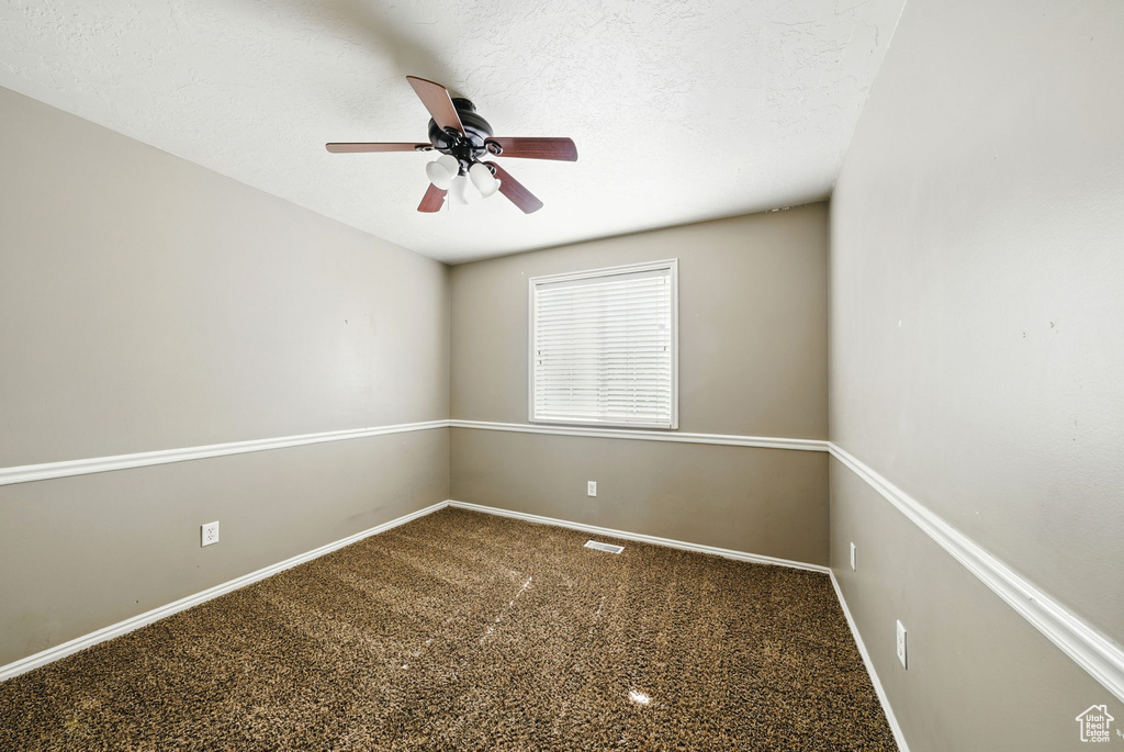 Empty room featuring ceiling fan, baseboards, and carpet floors