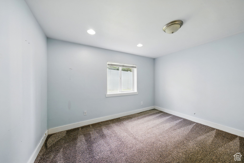 Carpeted empty room with baseboards and recessed lighting