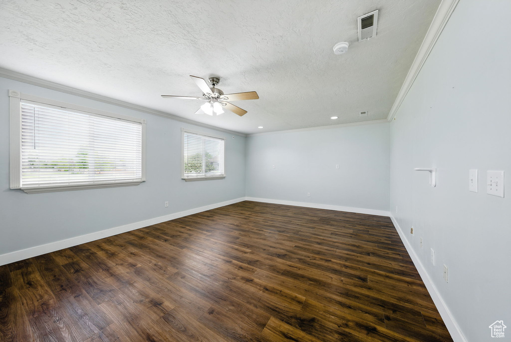Unfurnished room featuring crown molding, ceiling fan, wood finished floors, a textured ceiling, and a smoke detector
