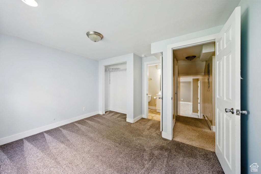 Unfurnished bedroom featuring carpet, baseboards, and a closet