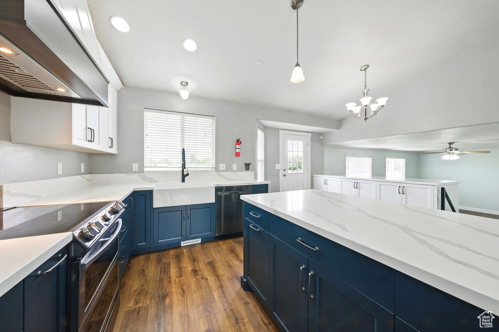 Kitchen featuring blue cabinets, wall chimney exhaust hood, black / electric stove, dark wood finished floors, and a sink