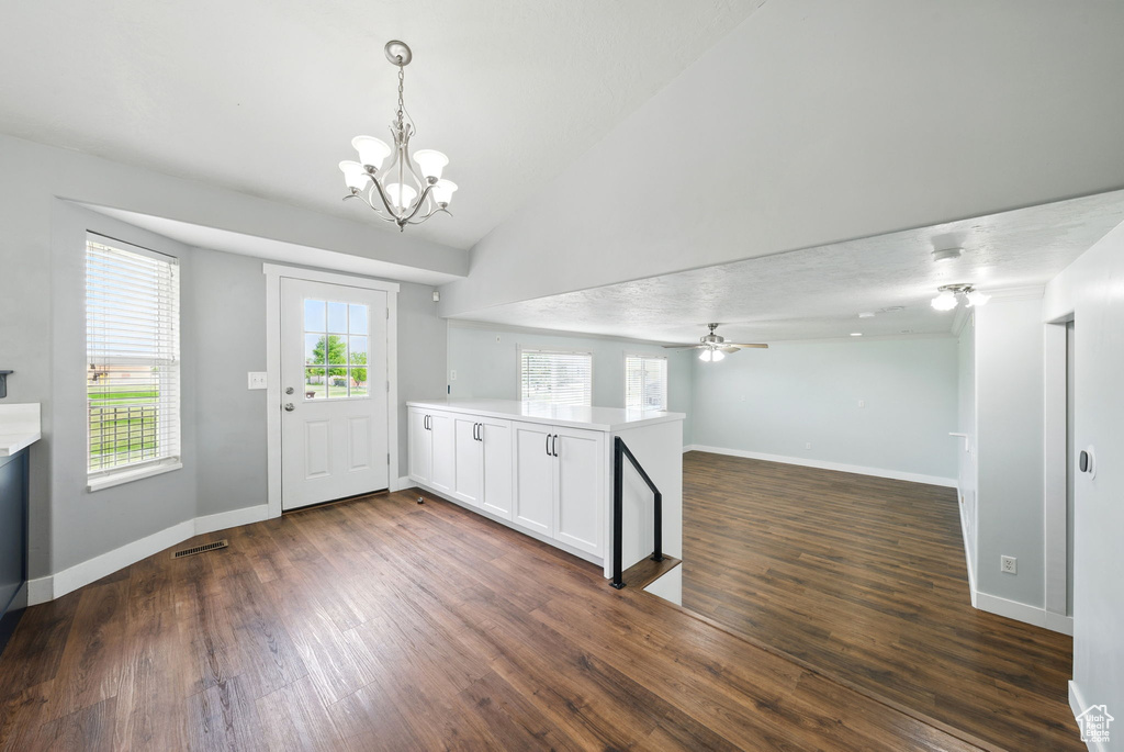 Entryway with a chandelier, dark wood-style floors, lofted ceiling, and baseboards