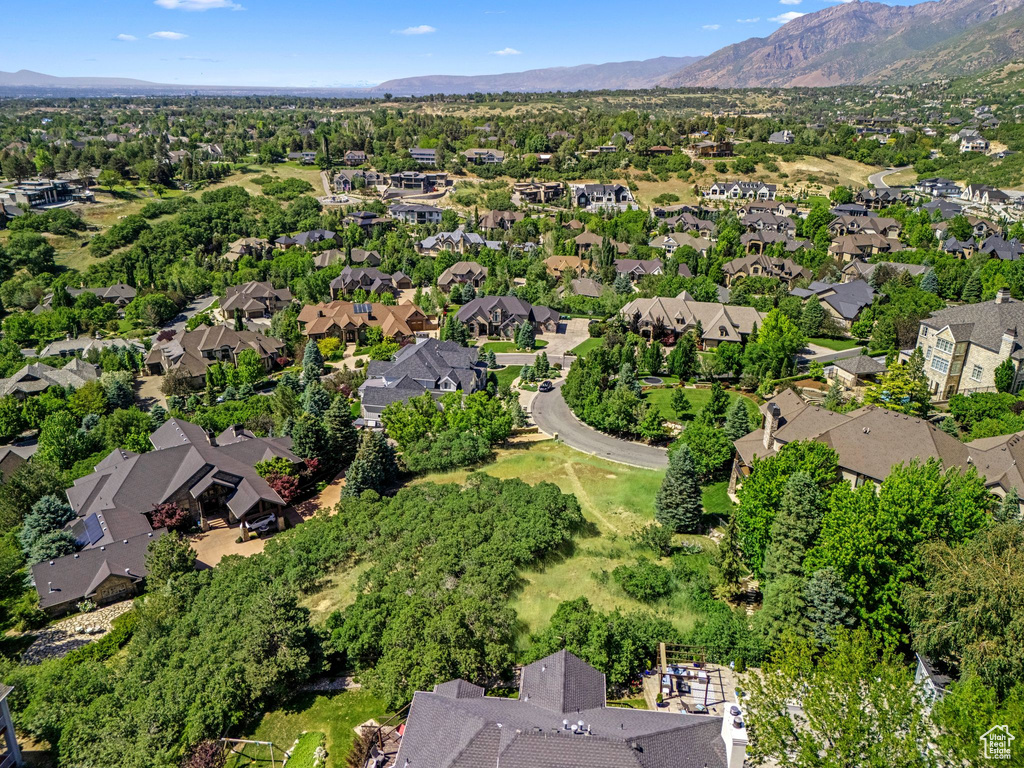 Aerial view of property and surrounding area with nearby suburban area and a mountain backdrop