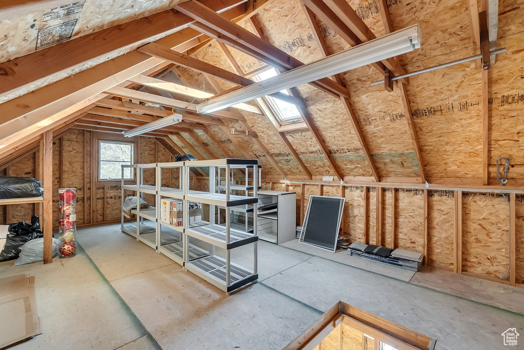 Unfinished attic featuring a skylight