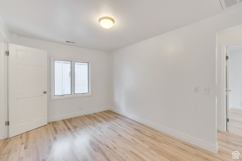 Unfurnished room featuring light wood finished floors and baseboards