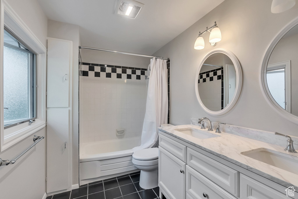 Full bathroom featuring tile patterned flooring, shower / bath combination with curtain, double vanity, and healthy amount of natural light