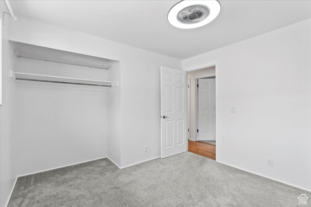 Unfurnished bedroom featuring carpet floors, baseboards, and a closet