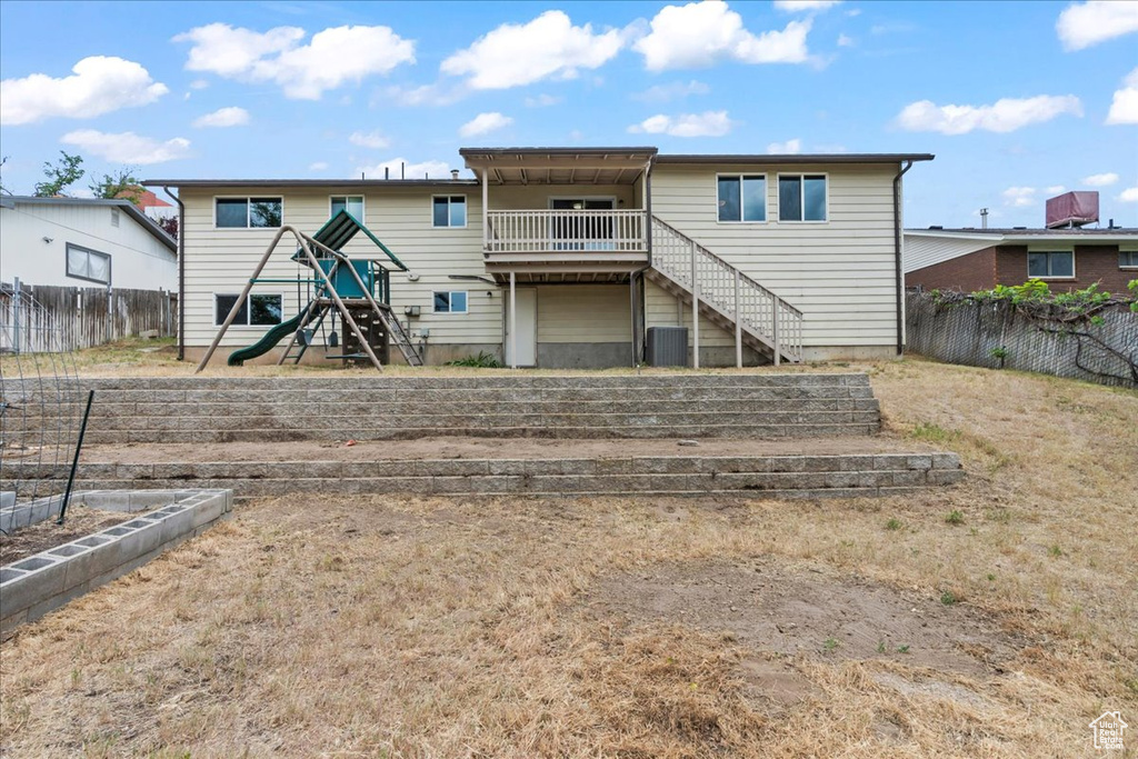 Back of house with stairway, a playground, and central air condition unit