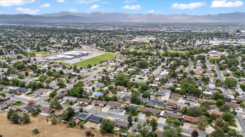 Aerial view of property and surrounding area with a mountain backdrop