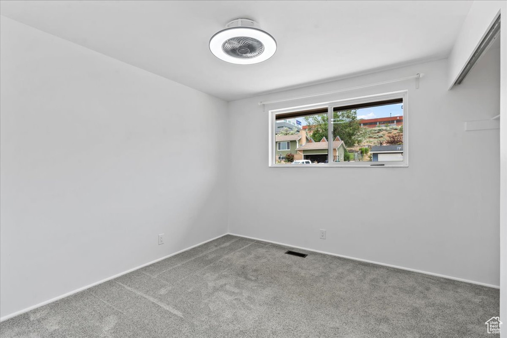 Empty room featuring carpet flooring and baseboards