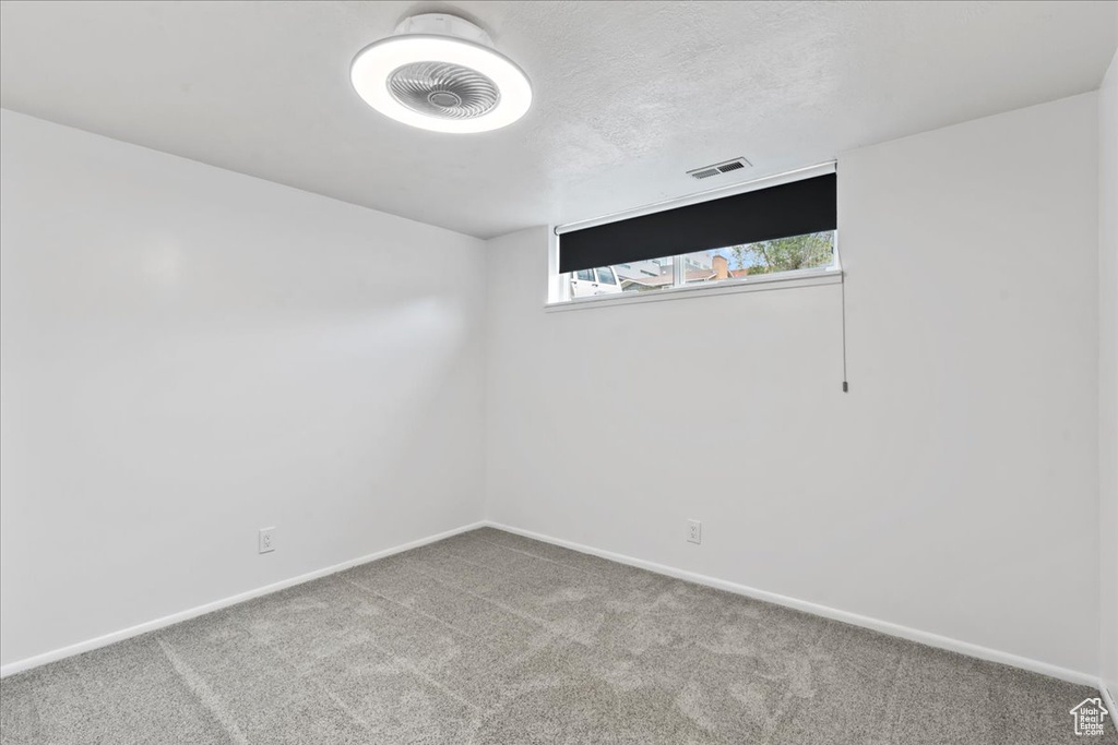 Carpeted spare room with baseboards