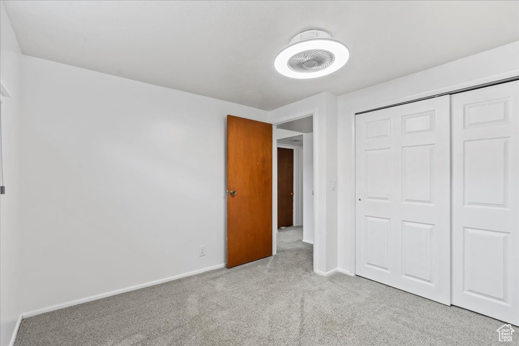 Unfurnished bedroom with carpet floors, baseboards, and a closet