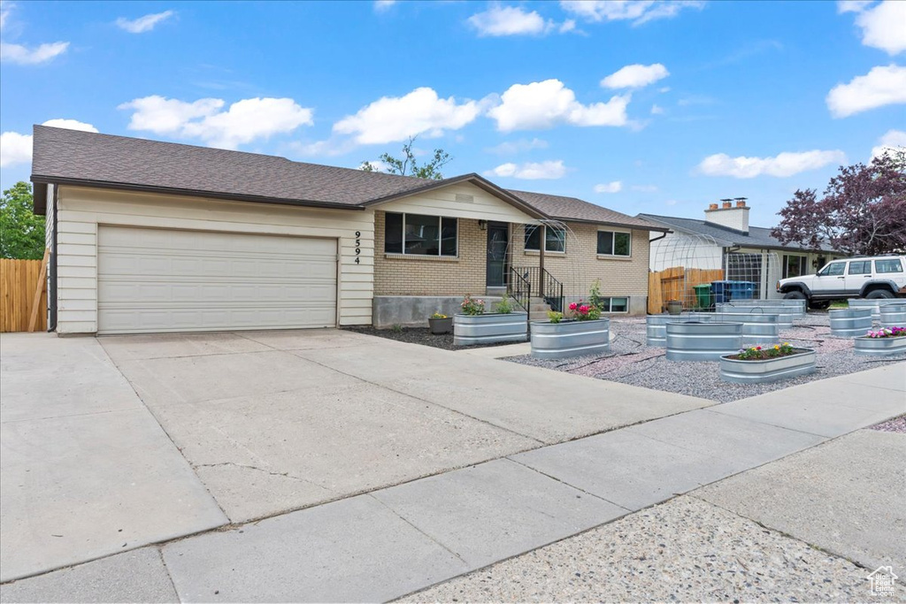Single story home with concrete driveway, an attached garage, and brick siding