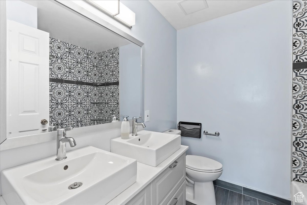 Bathroom featuring double vanity and toilet