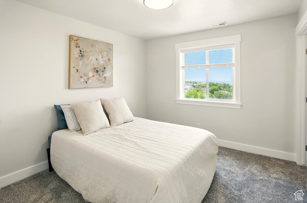 Bedroom featuring carpet and baseboards