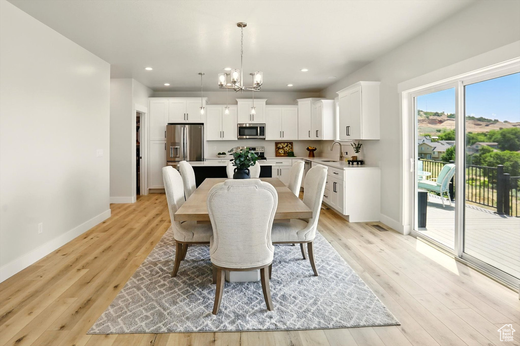 Dining room featuring a chandelier, baseboards, light wood-style flooring, and recessed lighting