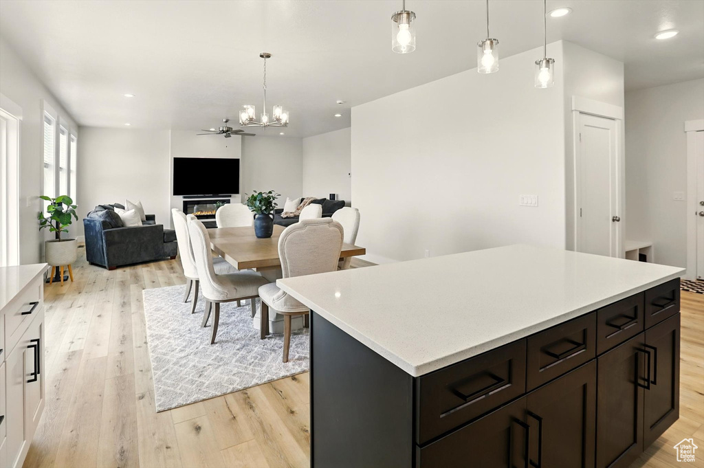 Kitchen featuring light wood-style floors, light countertops, pendant lighting, a center island, and recessed lighting