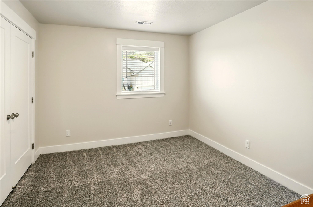 Empty room featuring carpet flooring and baseboards