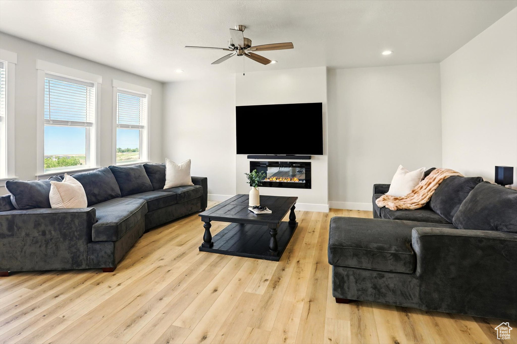 Living room with a ceiling fan, hardwood / wood-style floors, recessed lighting, and baseboards