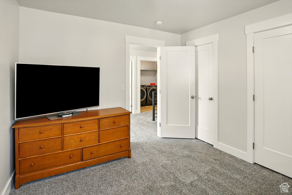 Bedroom featuring washer and clothes dryer, carpet, and baseboards