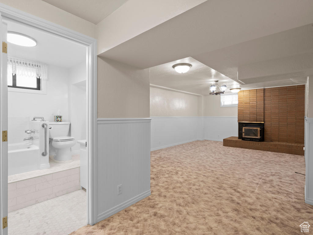 Below grade area with a brick fireplace and wainscoting