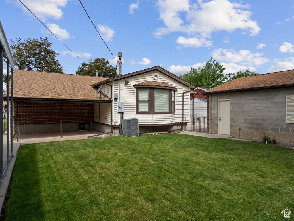 Back of property featuring a patio, central air condition unit, and roof with shingles