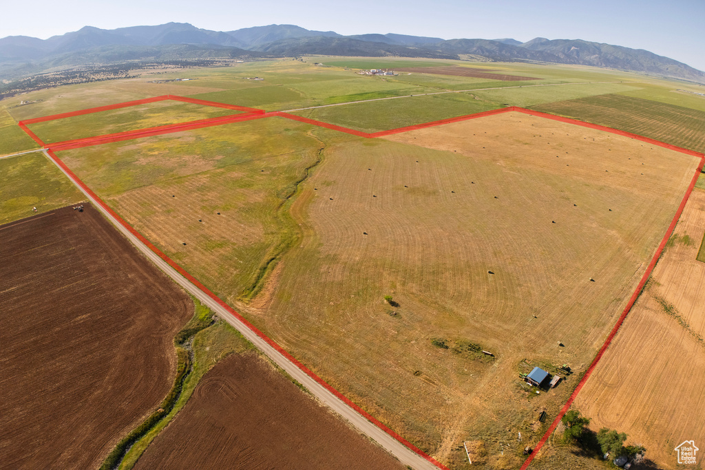Aerial view of sparsely populated area featuring property parcel outlined and a mountainous background